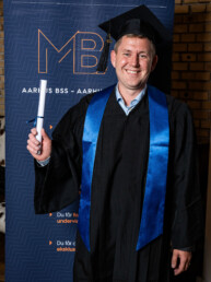 Glad MBA-dimittend med diplom ved Aarhus BSS, portrætfoto af Kasper Hornbæk.